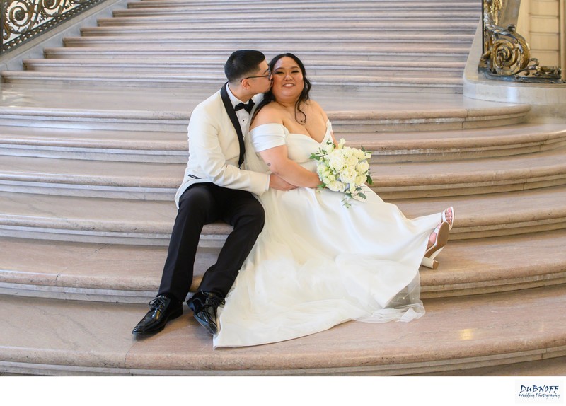 Groom kissing bride on the Staircase at SF City Hall