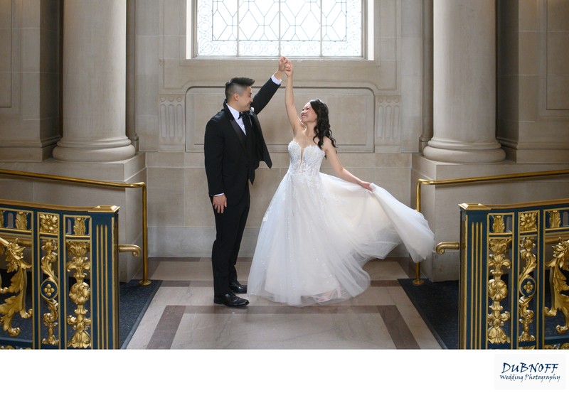 Asian Groom twirling Bride at San Francisco city hall