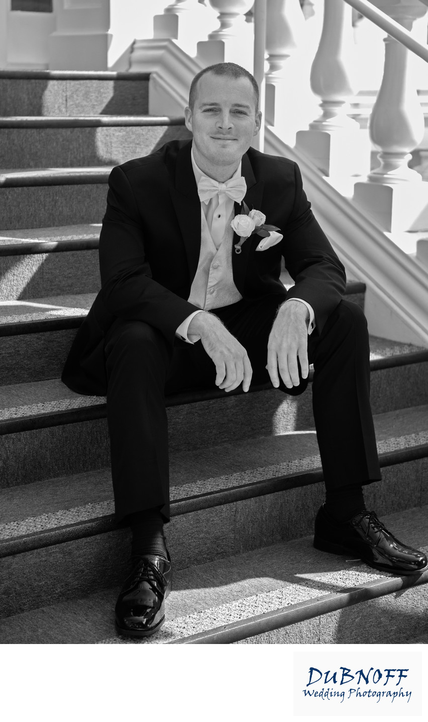 groom on mansion stairs black and white photography