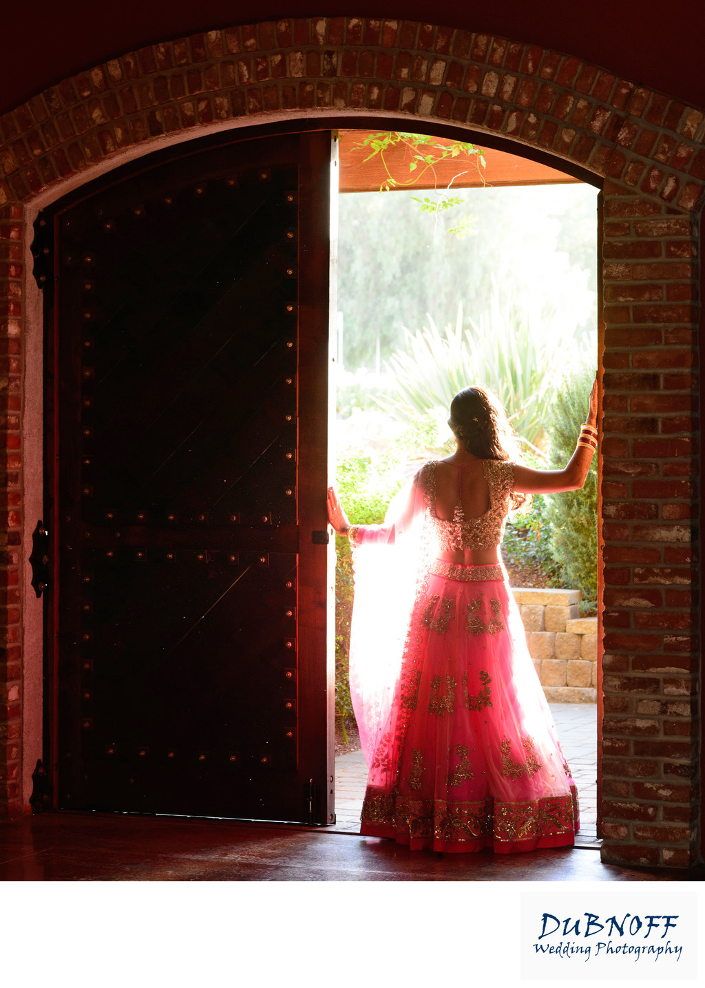 Bride in the Sunlit doorway into the wine cellar in the Bay Area