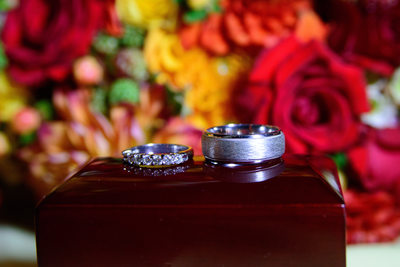 Wedding Rings on a box with Bouquet behind