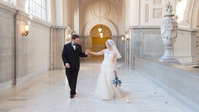 bride and groom walking on the 4th floor of San Francisco city hall
