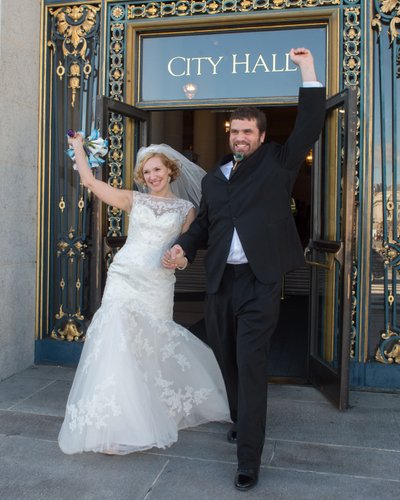 Bride and groom happily exiting San Francisco city hall after wedding