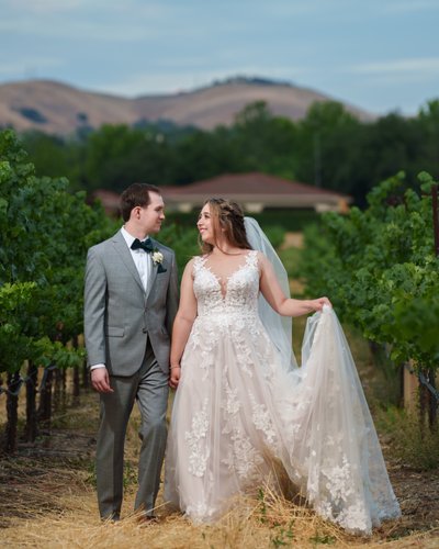 Newlyweds walking through Casa Real Vineyard in Livermore wine country
