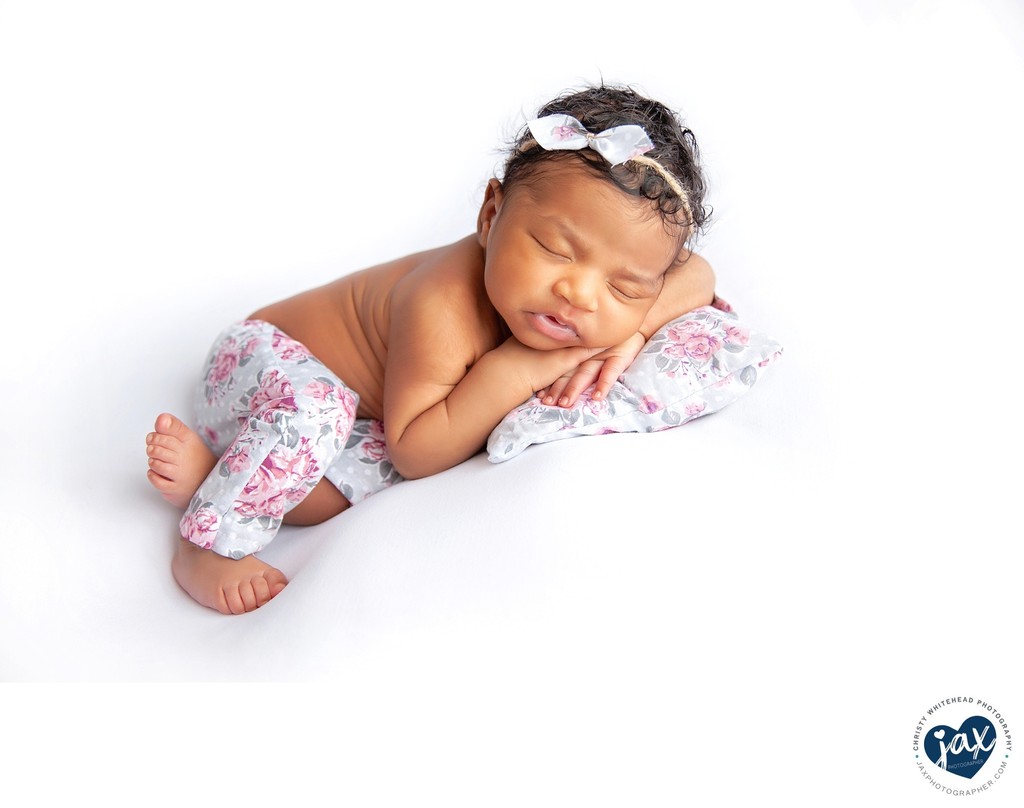 Gorgeous newborn black girl on floral pillow Jacksonville Florida