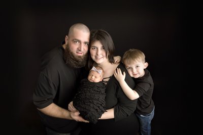 Family newborn photography portrait on black. Classic.
