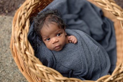 Baby boy wrapped in blue in a basket