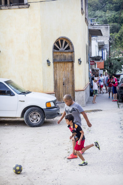 Puerto Vallarta Mexico, kids playing football in the street.