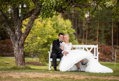 Bryllupsbilde av det gifte paret på en benk i Modum