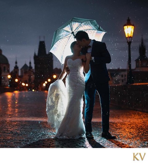 Bride & groom in the rain atop Charles Bridge pre wedding