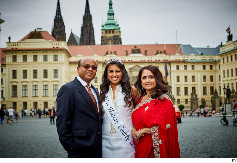 The happy parents and their daughter wearing a tiara 