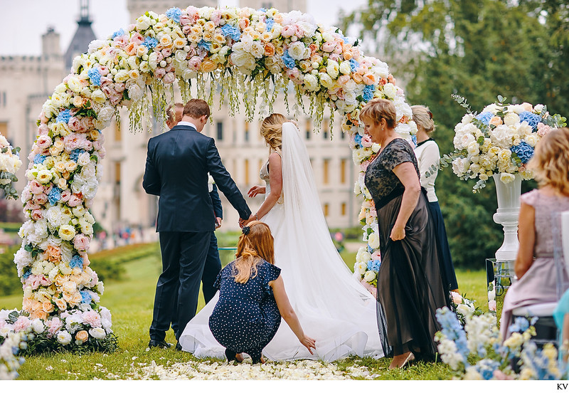 bride's sister adjusts her wedding dress