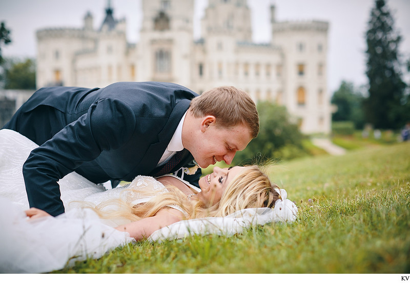 Kiss for the bride as she lies on the grass