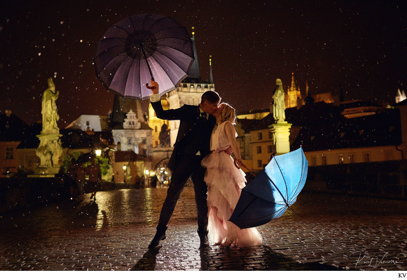 Kissing in the rain under umbrellas Charles Bridge