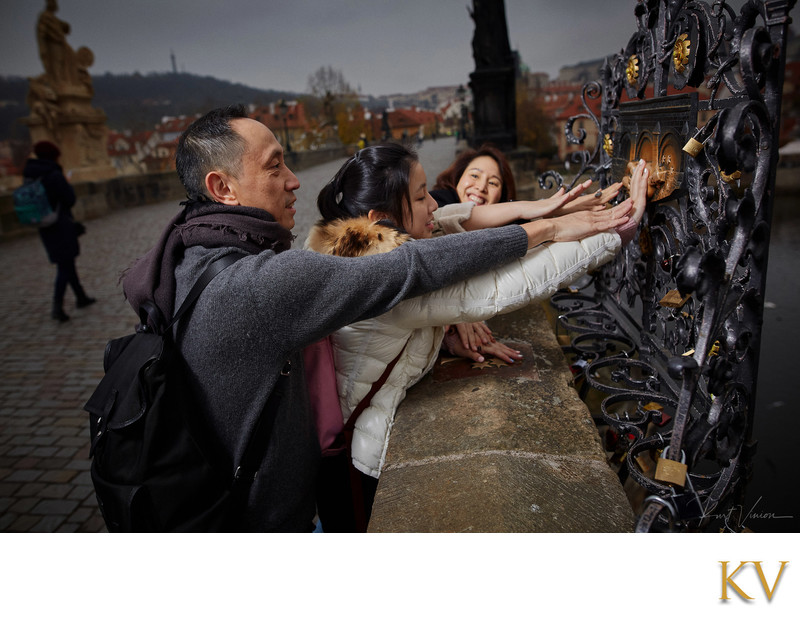 Family making a wish on the Charles Bridge