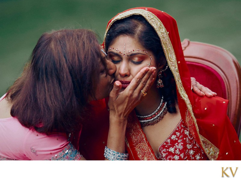 tearful Indian bride caressed by her mother