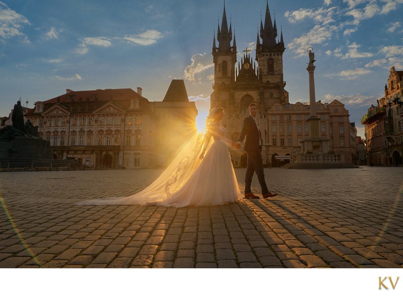 Groom Leading His Bridge Into The Old Town Square At Sunrise