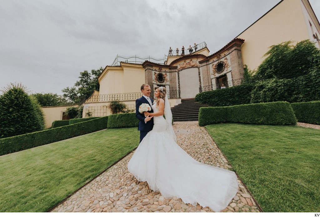 Newlyweds explore the garden as guests watch from above