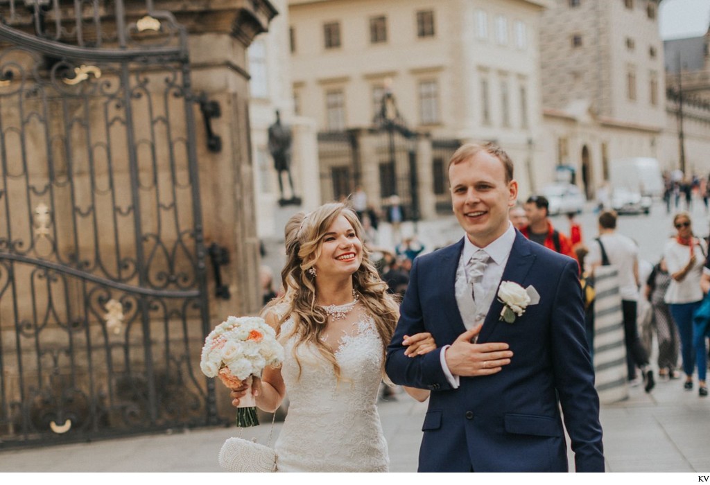 bride & groom walk near Prague Castle gates