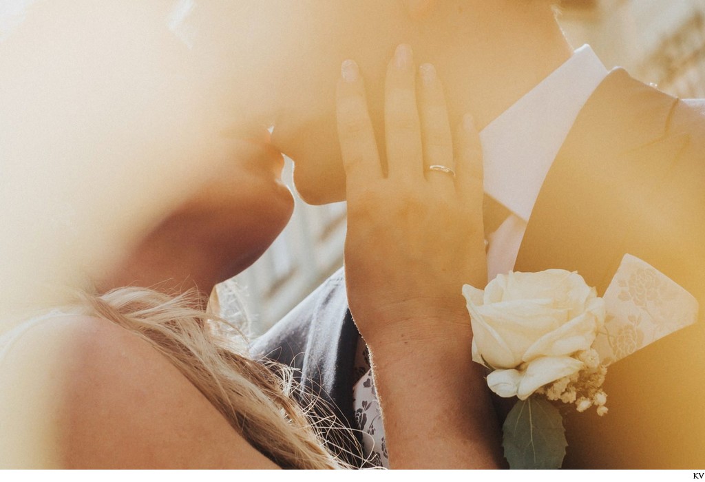 sun flared kiss of newlyweds