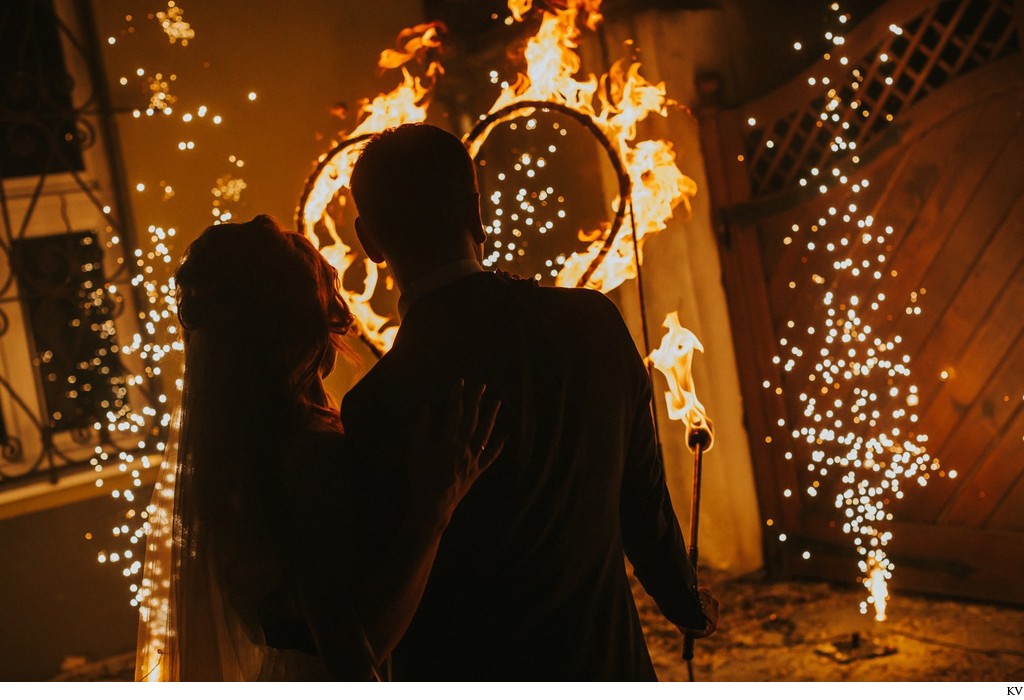 newlyweds watch as a heart burns in their honor