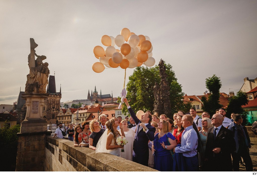 wedded couple releasing balloons on Charles Bridge