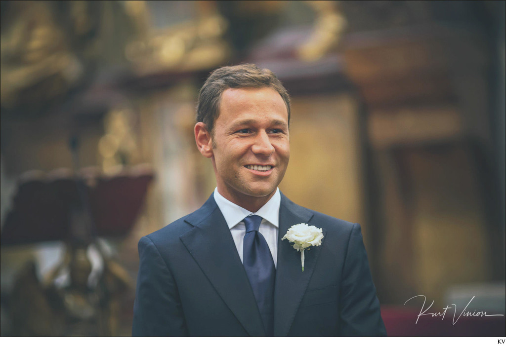 smiling groom waiting at the alter 