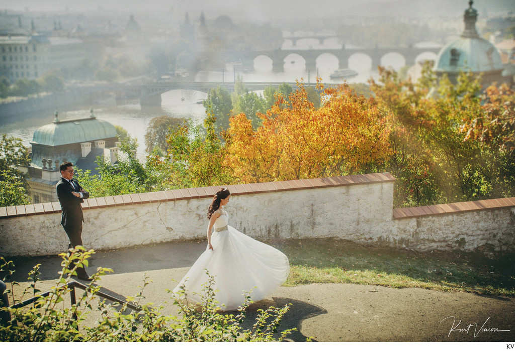 twirling Korean bride as groom watches above Prague 