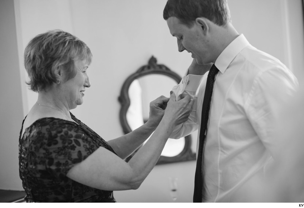 The mother of the groom assists with cuff links