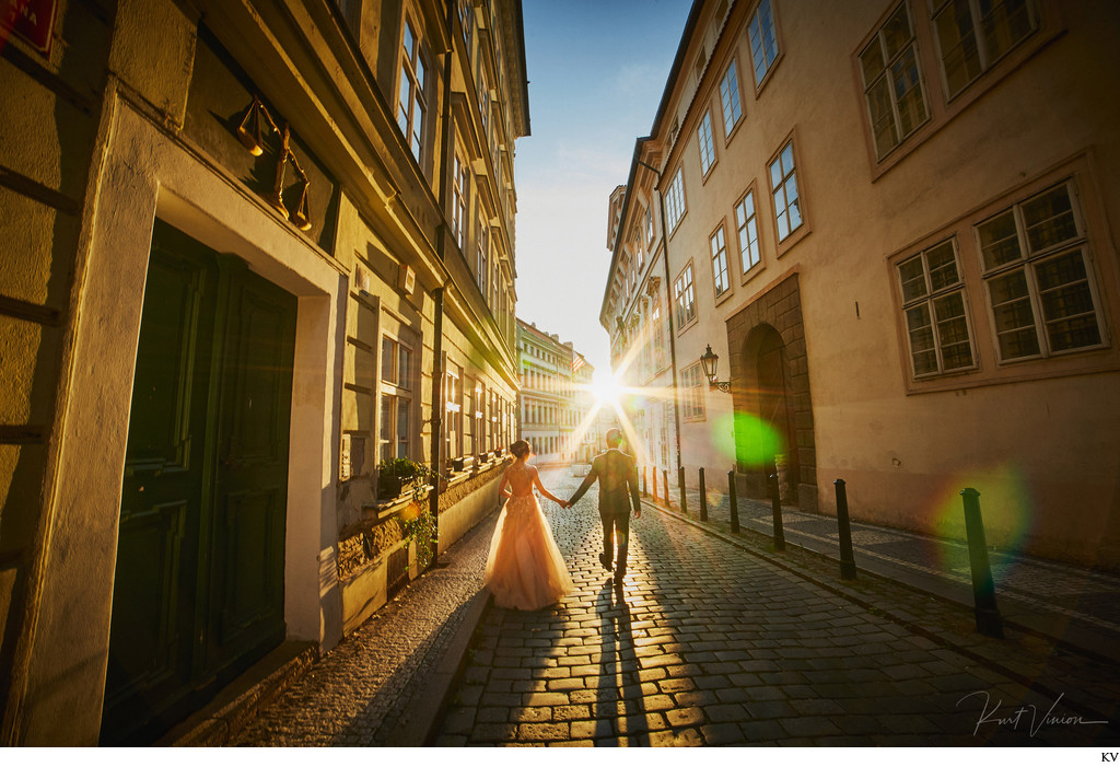 holding hands walking in sunshine historic Prague