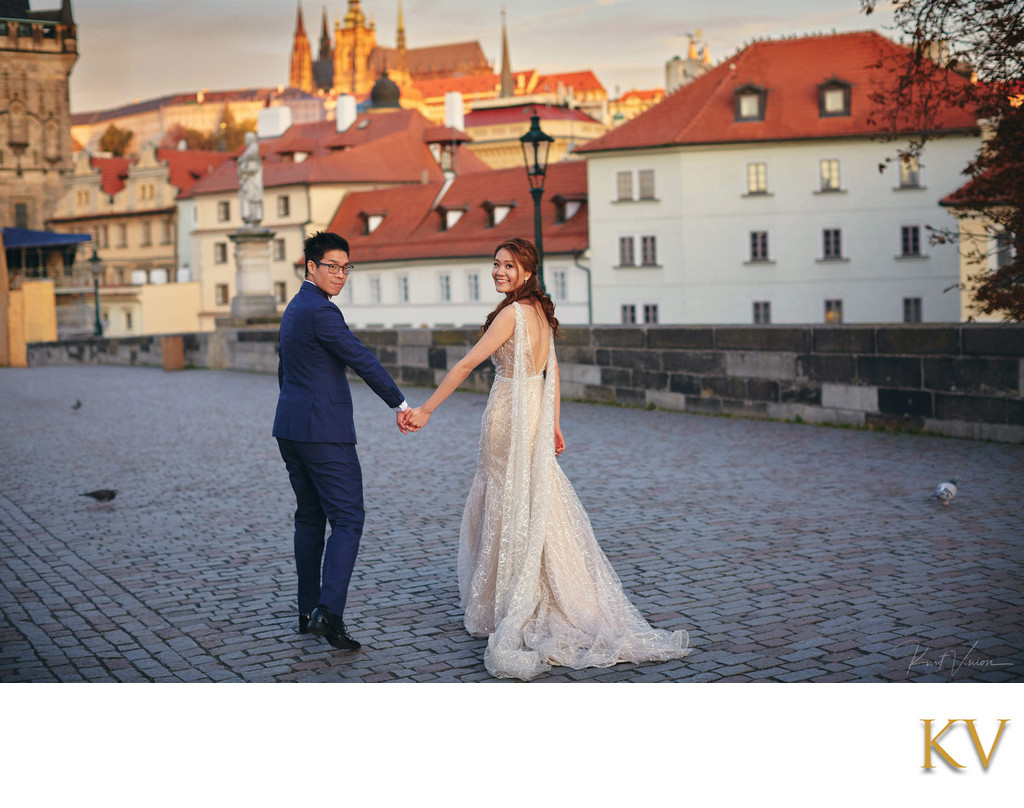 walking hand in hand across the Charles Bridge 