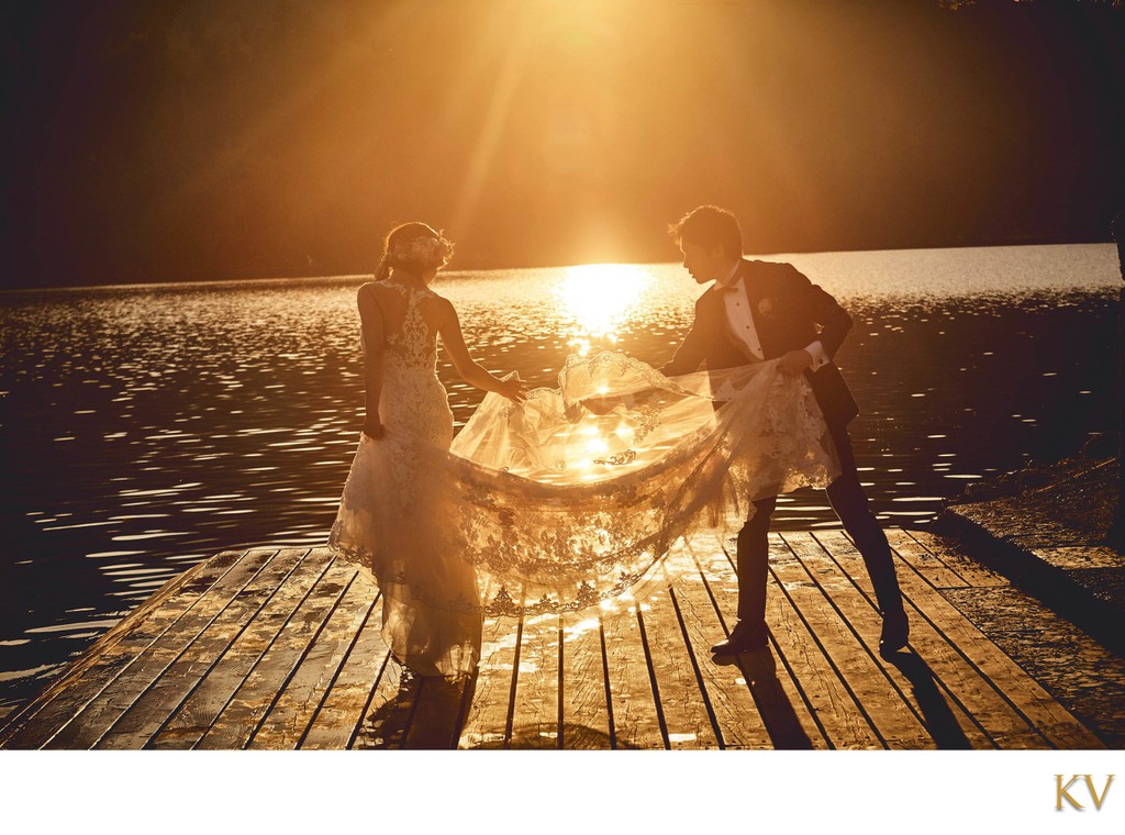 helping brides veil in the Golden Light of Lake Bled