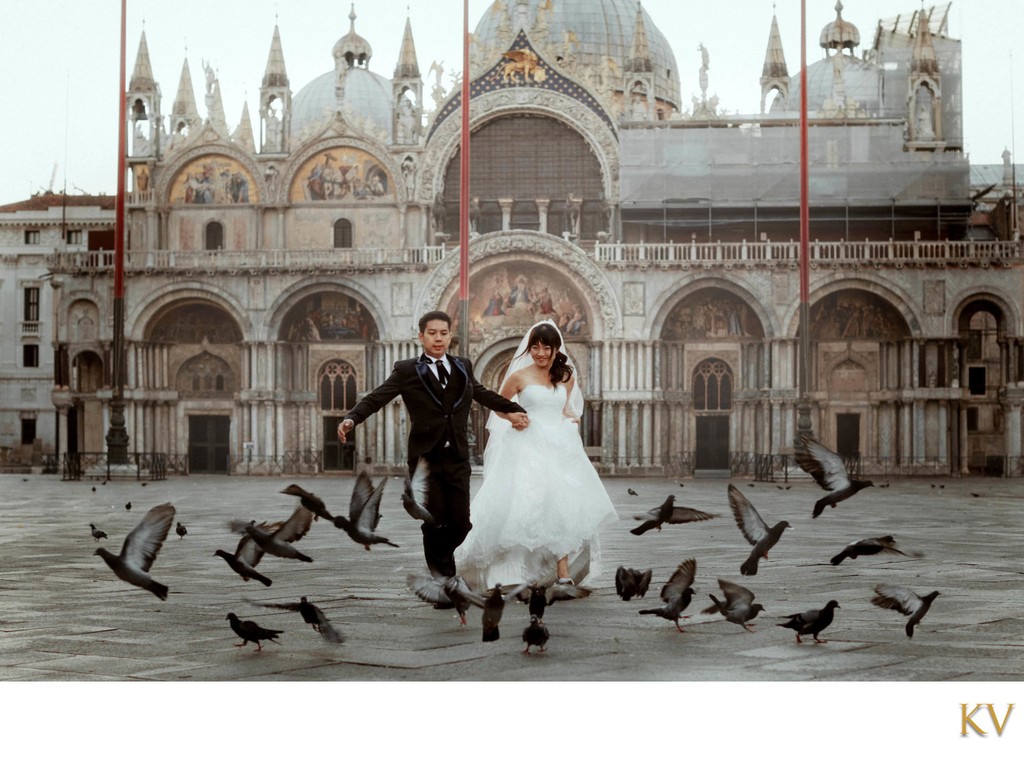 newlyweds running through pigeons St Mark's Basilica