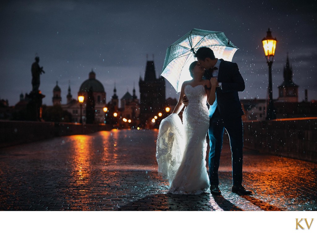 Hong Kong couple in the rain atop Charles Bridge at night