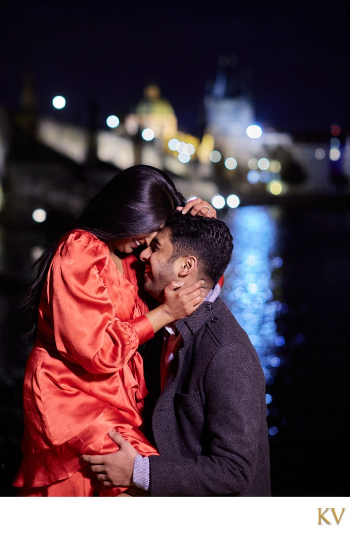 The happily engaged near the Charles Bridge at night