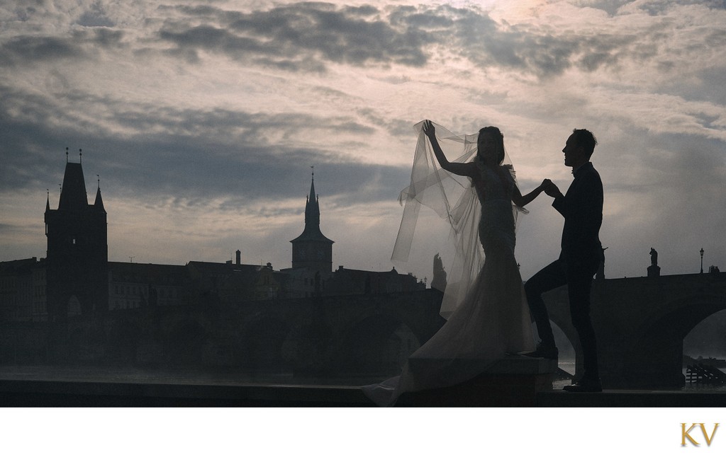 Bride & designer dress overlooking foggy Charles Bridge