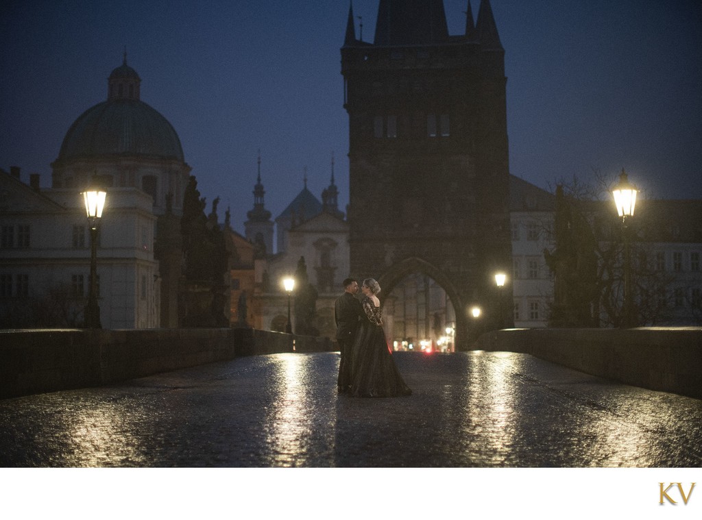 embracing in the solitude of the Charles Bridge at night