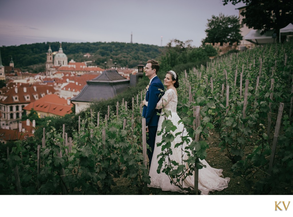 Newlyweds embrace in vineyards above Prague