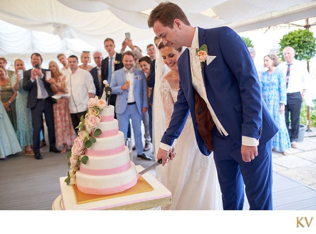 Newlyweds cut the wedding cake,a Villa Richter, Prague