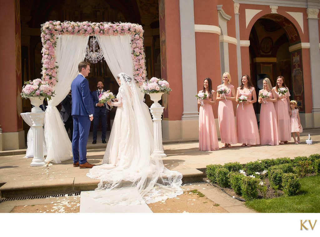 Bridesmaids watch as Bride and Groom exchange vows