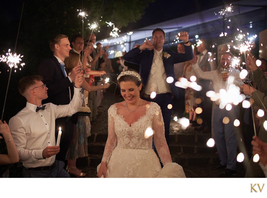 Wedding guests celebrate the bride and groom with sparklers