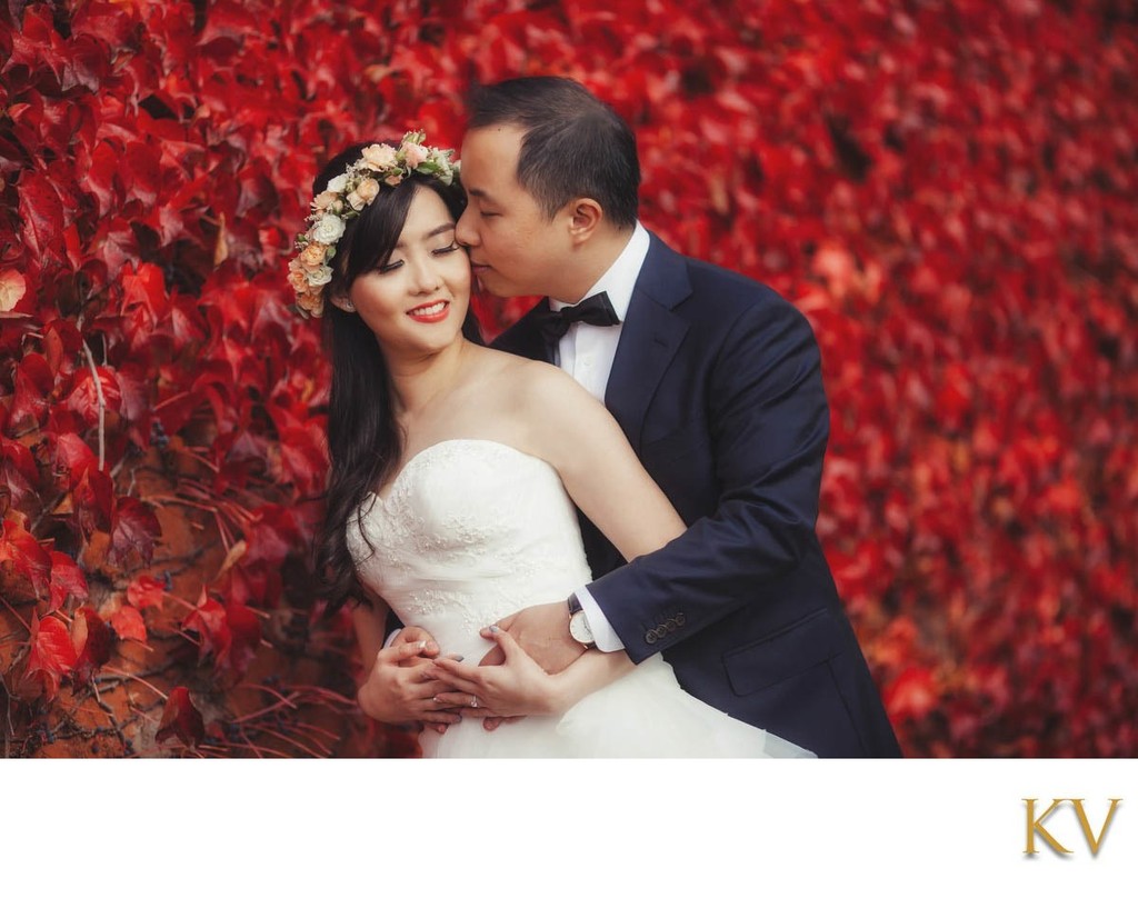 Ting & Jeff Embrace near the wall of red ivy in Prague