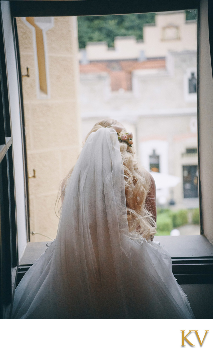 Bride peers outside of hotel window