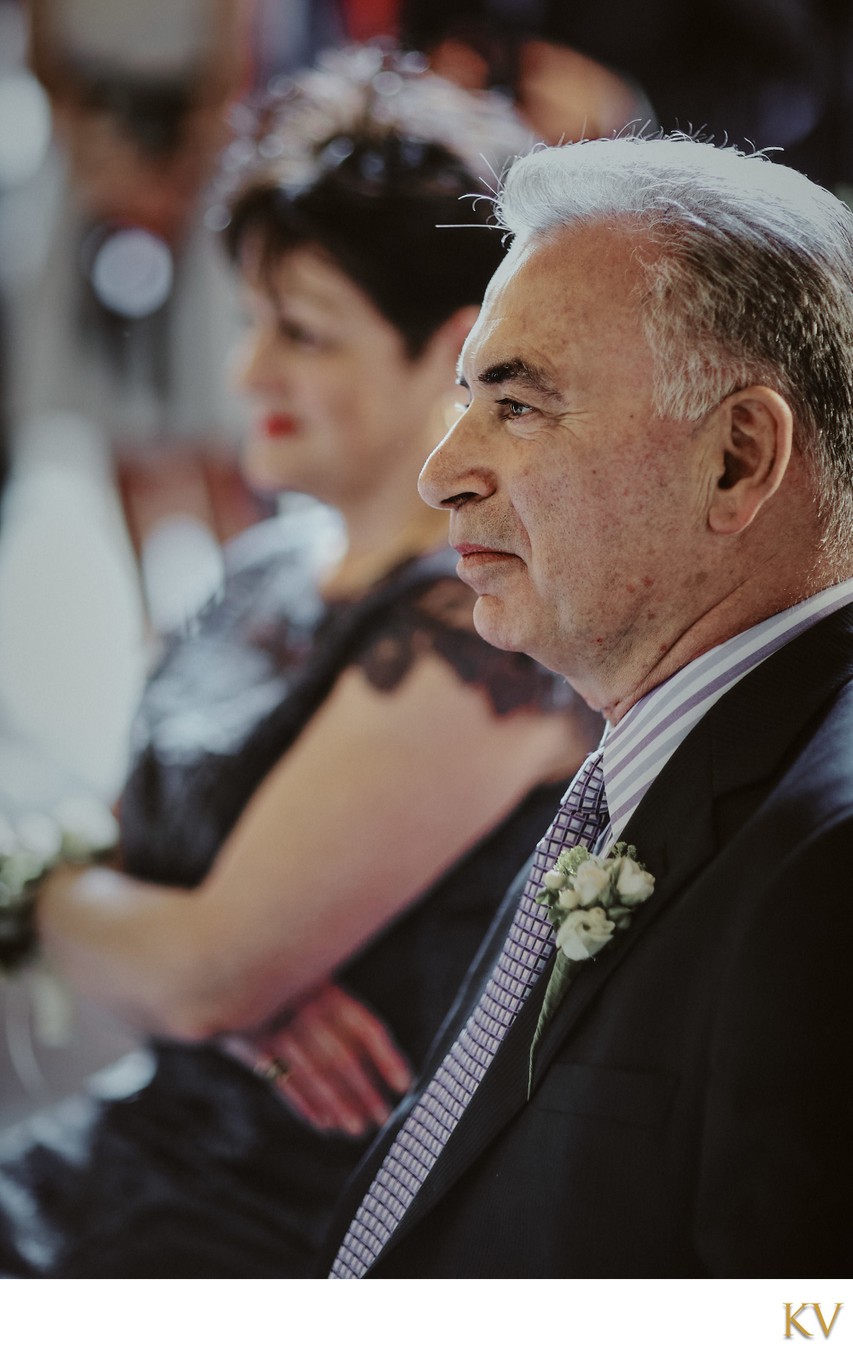 groom's father watches his son marry