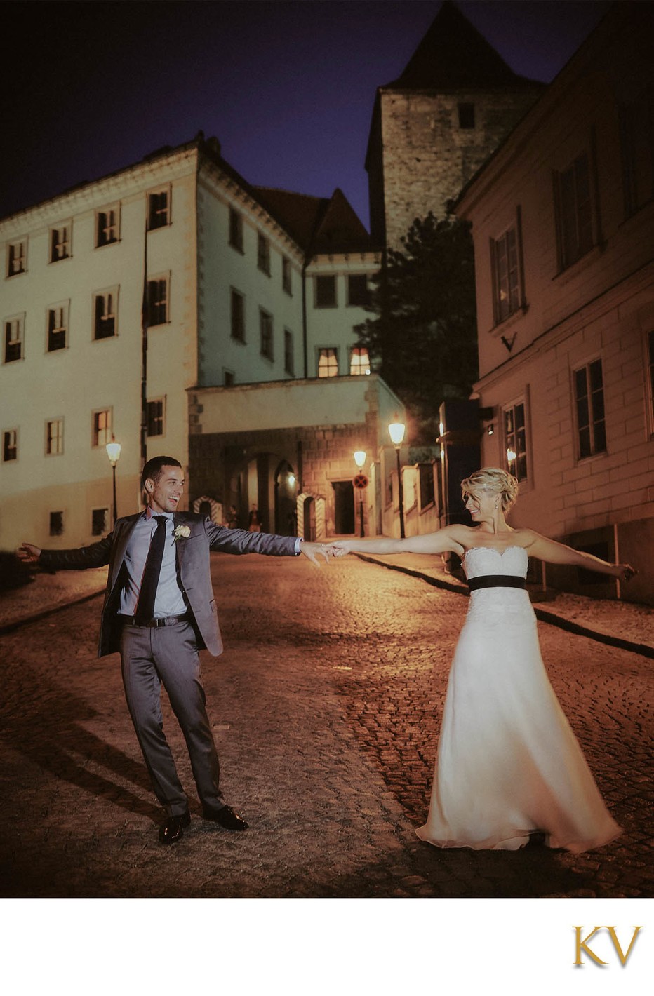 Newlyweds dancing at Prague Castle at night