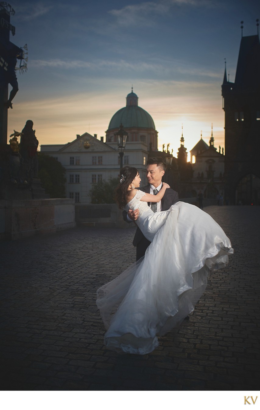 picking up his bride at sunrise atop Charles Bridge