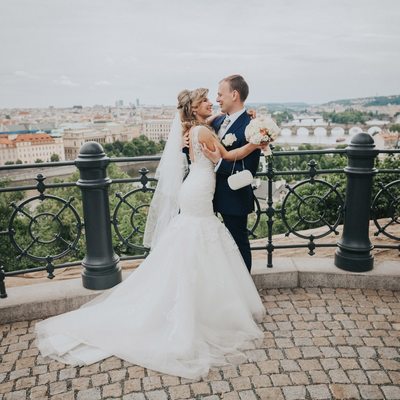 bride & groom embracing above Prague on wedding day