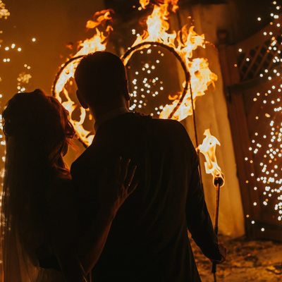 newlyweds watch as a heart burns in their honor