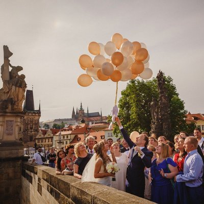 wedded couple releasing the balloons on Charles Bridge
