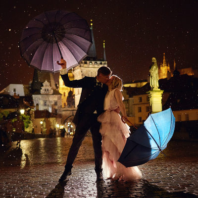 Kissing in the rain under umbrellas Charles Bridge